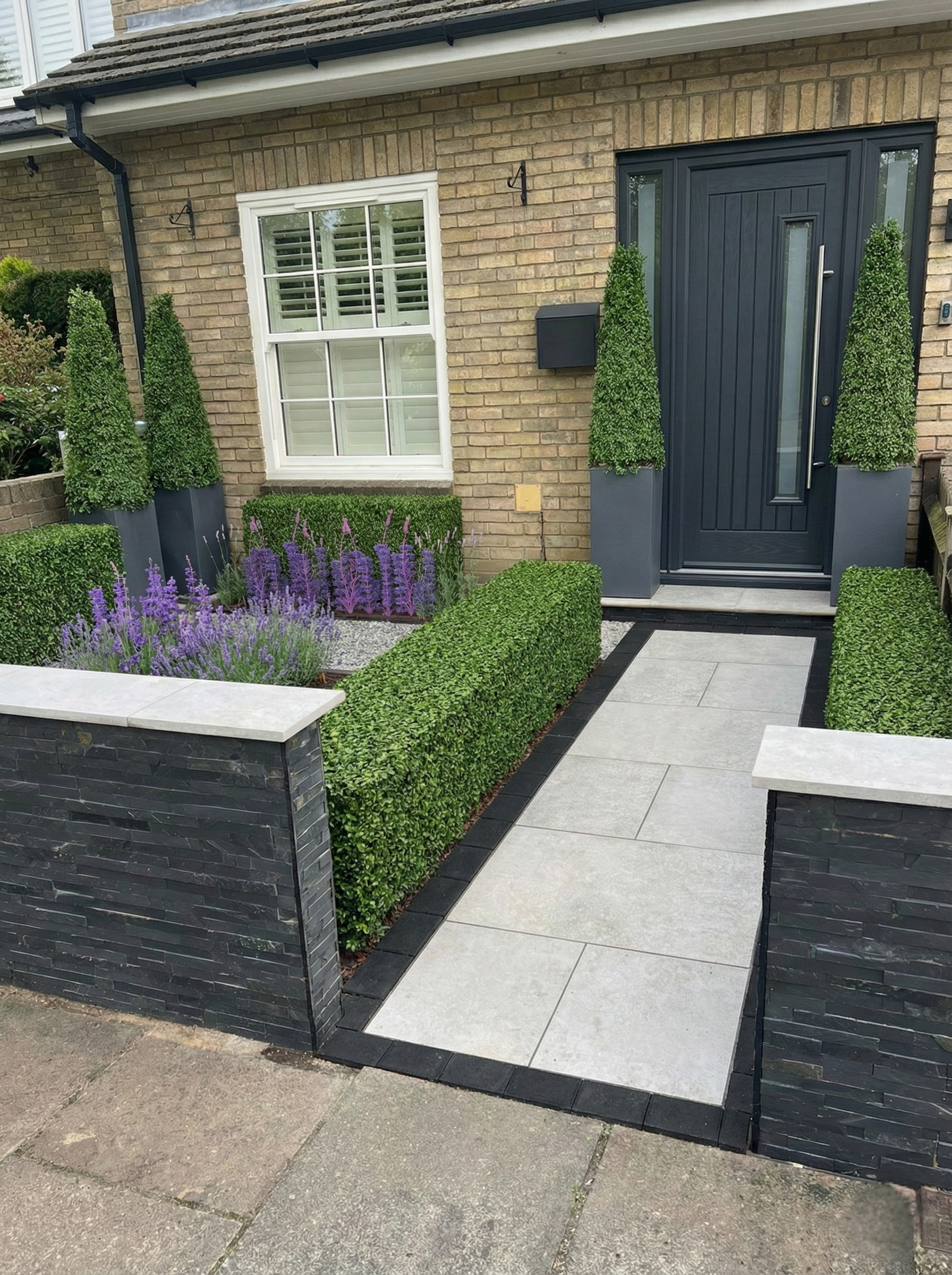 Daytime view of the sustainable garden with sleek Kandla Grey paving and bespoke fencing